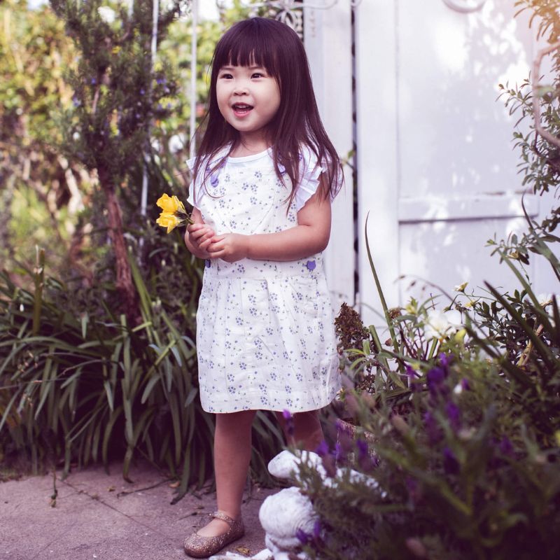 White floral summer dress for girls, featuring white straps and bespoke buttons, paired with matching knickers. 