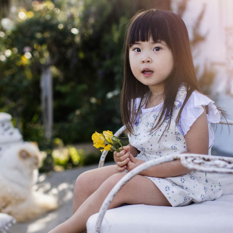 White floral summer dress for girls, featuring white straps and bespoke buttons, paired with matching knickers. 