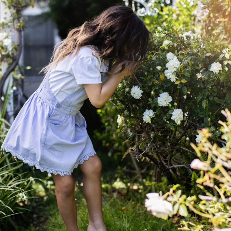 Lilac summer dress for girls with overall straps and a ruffled hemline, with matching knickers with a floral pattern