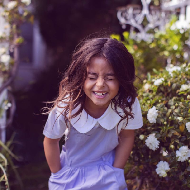 Lilac summer dress for girls with overall straps and a ruffled hemline, with matching knickers with a floral pattern